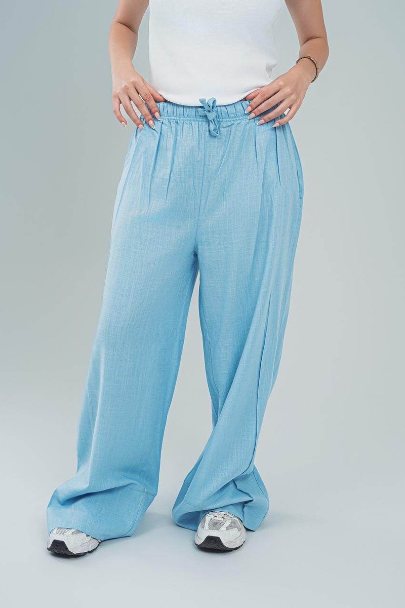 Beige linen palazzo trousers for women with drawstring waist by FAIR & SQUARE paired with white top and sneakers